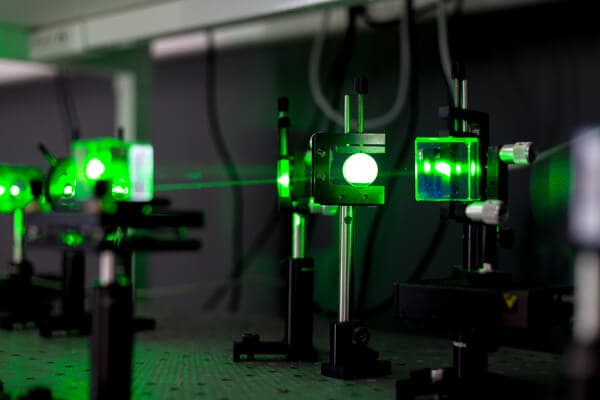Une machine de gravure laser grave une photo sur un bloc de cristal